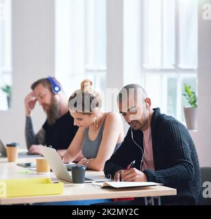 College students sitting at table in class working on project Stock Photo
