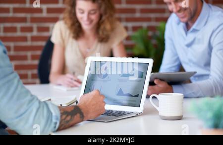 businessman using laptop computer meeting with colleagues discussing financial graph data on screen Stock Photo