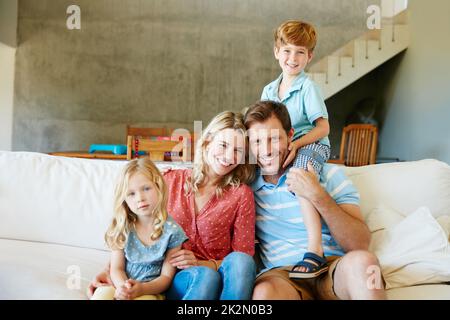 The happiest are those that have family. Portrait of a happy family bonding together at home. Stock Photo