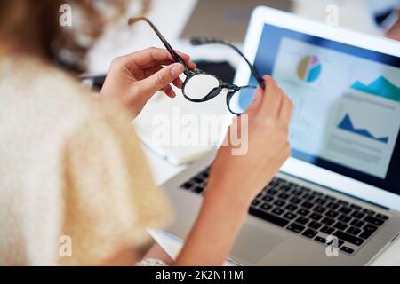 business woman hands holding glasses with laptop computer showing financial data on screen Stock Photo