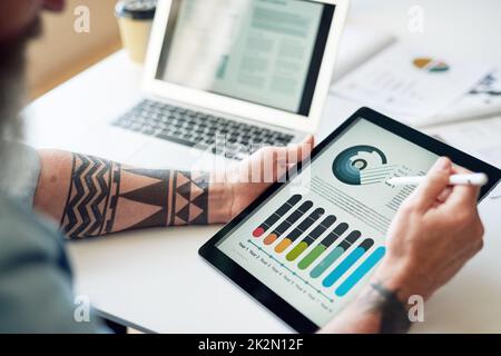 businessman using tablet computer with financial graph data on mobile device screen holding stylus Stock Photo