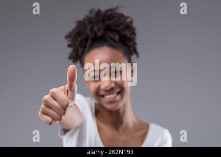 Happy smiling young teenage girl giving a thumbs up Stock Photo