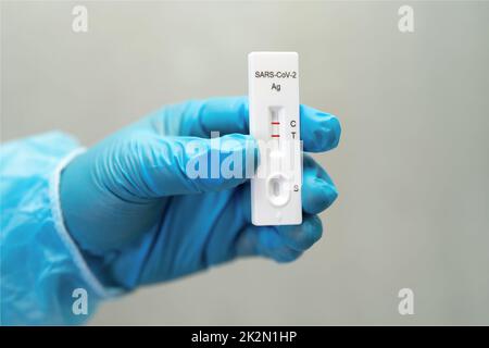 Asian doctor in PPE suit show positive test result with Saliva A Stock Photo