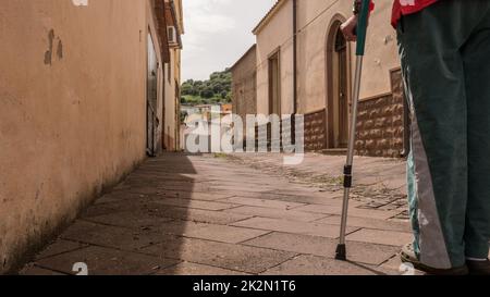 elderly man falling on crutches from the stairs in the house, losing his balance by tripping on crutches and falling to the ground. domestic injury. Stock Photo