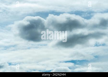 White and gray fluffy clouds on blue sky. Soft touch feeling like cotton. White puffy cloudscape. Beauty in nature. Close-up white clouds texture background. Cloudy sky. Background for tranquility. Stock Photo