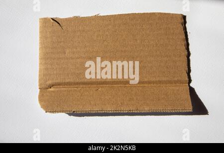 A torn piece of kraft cardboard on a white background. Template, place for text Stock Photo