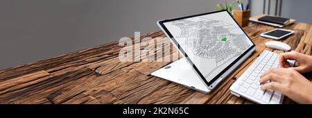 Businessperson Analyzing Cadastre Map On Computer Stock Photo