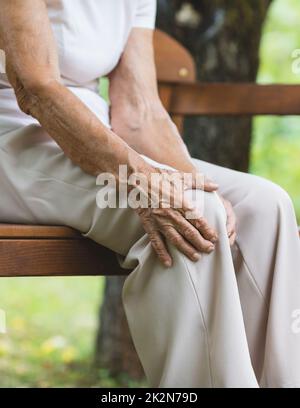 Senior woman holding her painful knee Stock Photo