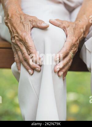 Senior woman holding her painful knee Stock Photo