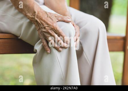 Senior woman holding her painful knee Stock Photo