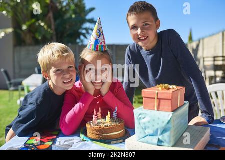 Let the birthday fun and festivities begin. Portrait of a group of young children enjoying an outdoor birthday party. Stock Photo