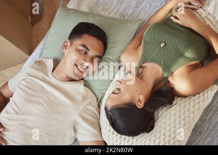 What do you think of the place. Shot of a young couple lying on the floor in their new home. Stock Photo