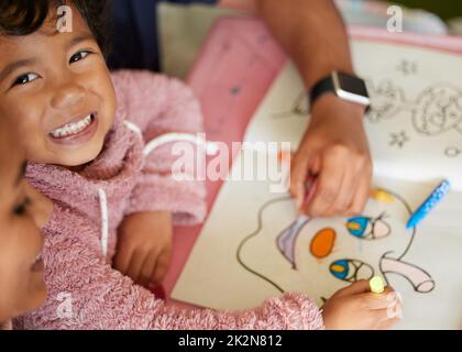 Colouring in with my mom is my favourite thing. Shot of a little girl and her mother colouring in a book. Stock Photo