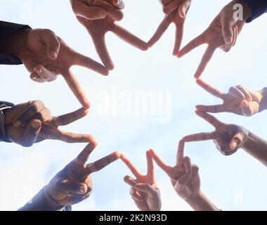 Youre a star in my eyes. Below shot of a group of unrecognizable businesspeople joining their hands against a white background. Stock Photo
