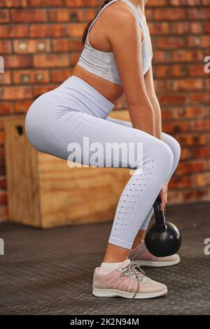 Cropped shot of slim body woman with flat belly in black leggings and sports  bra, standing in crossfit gym Stock Photo