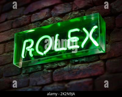 ROLEX watch sign illuminated in neon. Luxury Brand watches Dealer Stock Photo