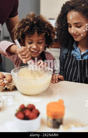 Having fun while learning moms special recipe. Cropped shot of a young boy and girl baking in the kitchen at home. Stock Photo