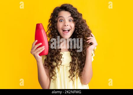 Teenage girl with shampoos conditioners or shower gel. Kids hair care cosmetic product, shampoo bottle. Excited teenager, glad amazed and overjoyed Stock Photo
