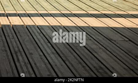 Regular exterior wooden board floor, sun casting shadow from side. Stock Photo