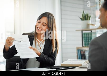 Please read this carefully before you sign. Shot of a female lawyer helping her client sign a contract. Stock Photo