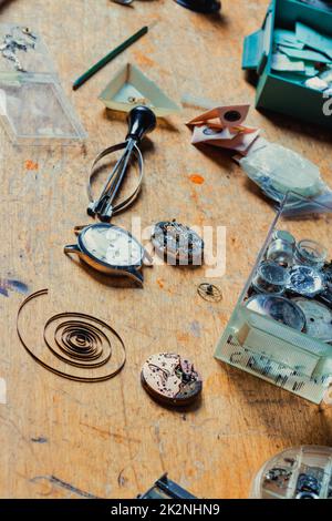 Watchmakers workbench with scattered tools and mechanisms Stock Photo