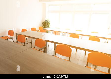Empty desks and chairs in high key cafeteria room Stock Photo
