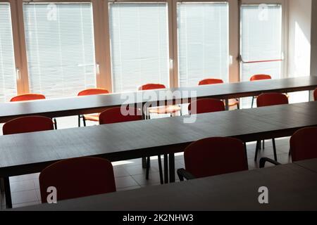 Empty desks and chairs in deserted office room Stock Photo