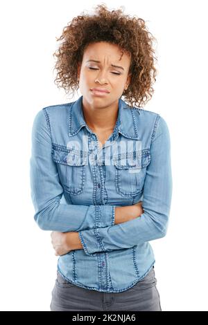 Dont let menstrual cramps get you down. Studio shot of a young woman experiencing stomach pain against a white background. Stock Photo