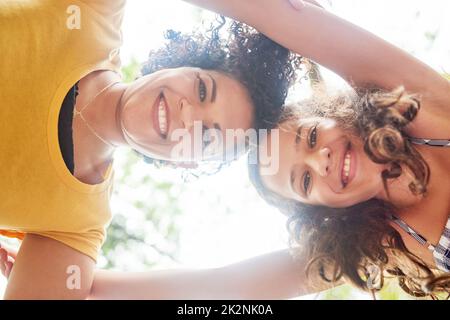 Were two of a kind. Low angle portrait of an adorable little girl and her mother standing hunched over in the park. Stock Photo
