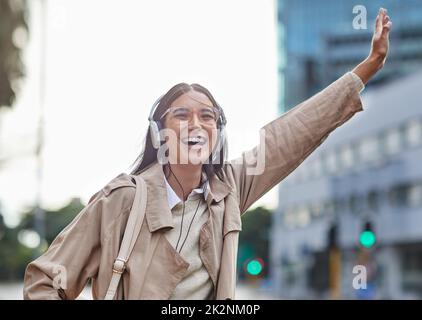 I hope this cab stops for me. Shot of a young businesswoman hailing a cab in town. Stock Photo