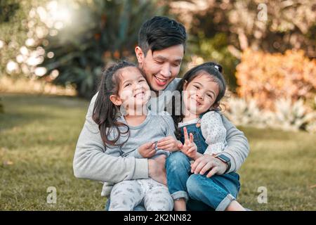 I love my two little girls. Shot of a father bonding with his two young daughters outside. Stock Photo