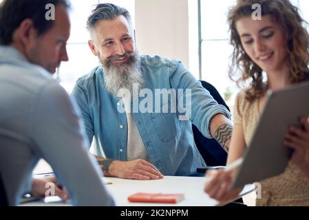 businessman team leader meeting with colleagues in office with business woman using tablet computer presenting ideas for company development Stock Photo
