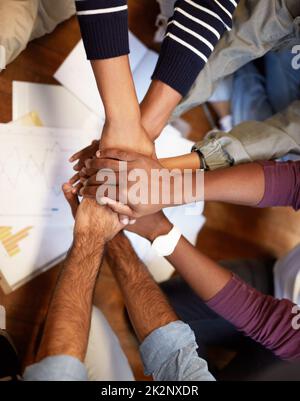 Weve got this. High angle shot of a group of people joining their hands together. Stock Photo