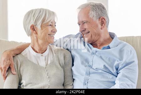 I love the way they love each other. Shot of a mature couple being affectionate on the sofa at home. Stock Photo