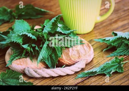 Medicinal plant-fresh stinging nettle on a cutting board . Ready for tea Stock Photo
