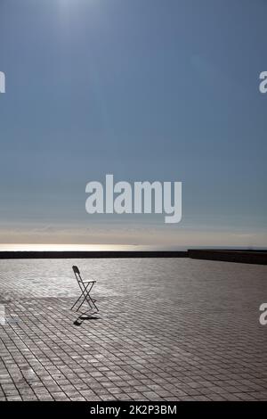 A wooden chair standing in the middle of an empty stage. Loneliness concept with one chair Stock Photo