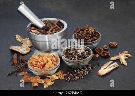 Chinese herbal plant medicine for holistic healthcare. Alternative preventative natural healing concept with dried herbs and spice. On mottled grey. Stock Photo