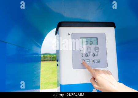 Automatic tire inflator. Hand press touch screen button on digital display of automatic tire inflator machine to set air pressure level. Self service air compressor tank in petrol pump or gas station. Stock Photo