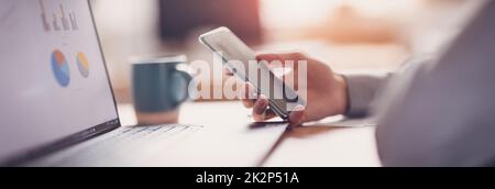 Young man working with laptop and smartphone in the office. Stock Photo
