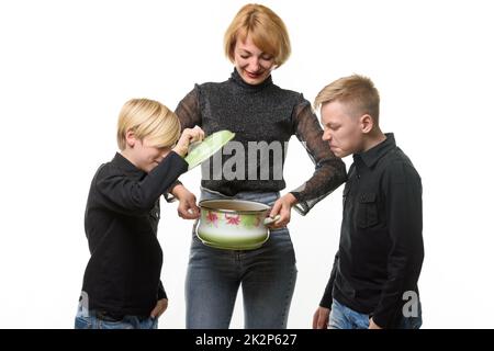 Mom cooked the soup, the children opened the pot and they did not like the food, isolated on a white background Stock Photo