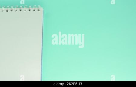 One white sheet of paper torn from a notebook, on a light green background with a copy of the space Stock Photo