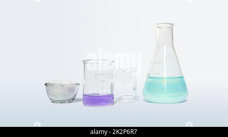 Microcrystalline wax in glass container glass place next to Potassium Permanganate Liquid in beaker and Iron (II) sulfate liquid in Erlenmeyer flask. Side View Stock Photo