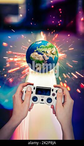 Games played around the world. Hand and joystick. Macro world. Political games. Game analogy to wars around the world. Photo manipulation. Stock Photo