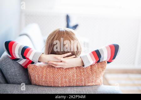 Tired woman lying down on the couch after workday. Stock Photo