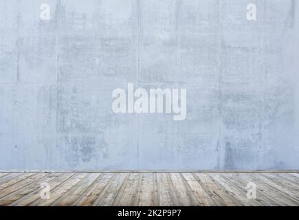 Concrete wall and brown wooden floor in empty loft Stock Photo