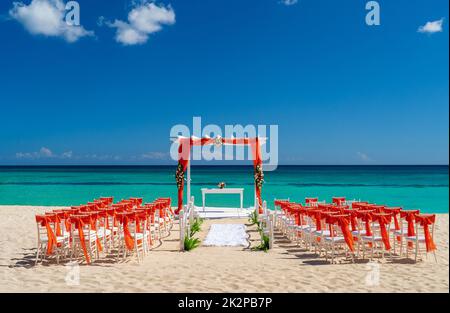 Romantic Wedding setting up with red decorations on the beach. Stock Photo