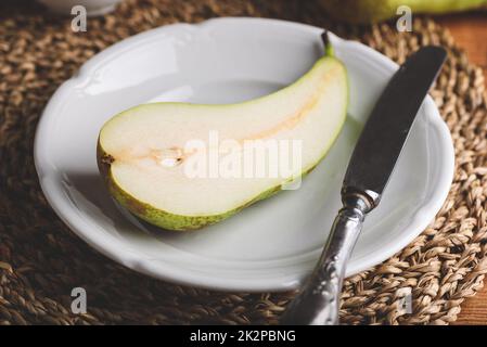 Half of Conference Pear on Plate Stock Photo