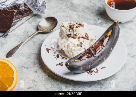 Grilled banana with dark chocolate and vanilla ice cream. Stock Photo