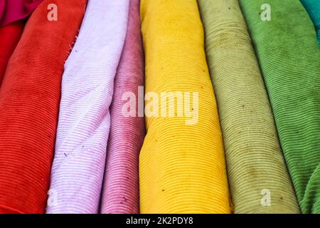 Samples of cloth and fabrics in different colors found at a fabrics market. Stock Photo