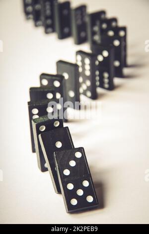 Black dominoes chain on white table background Stock Photo